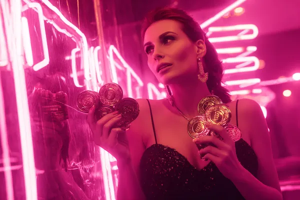 A glamorous woman holding casino chips in a neon-lit environment, representing the premium online casino atmosphere of HHBD.